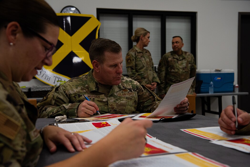 Participants compete in the 2nd annual challenge of the feathers contest during the Bazaar of Falcons event, Goodfellow Air Force Base, Texas, Aug. 26, 2022. The 81st Training Wing challenged participants to crack a series of ciphers to demonstrate the challenges faced by Airmen operating within the cyber enterprise. (U.S. Air Force photo by Senior Airman Michael Bowman)