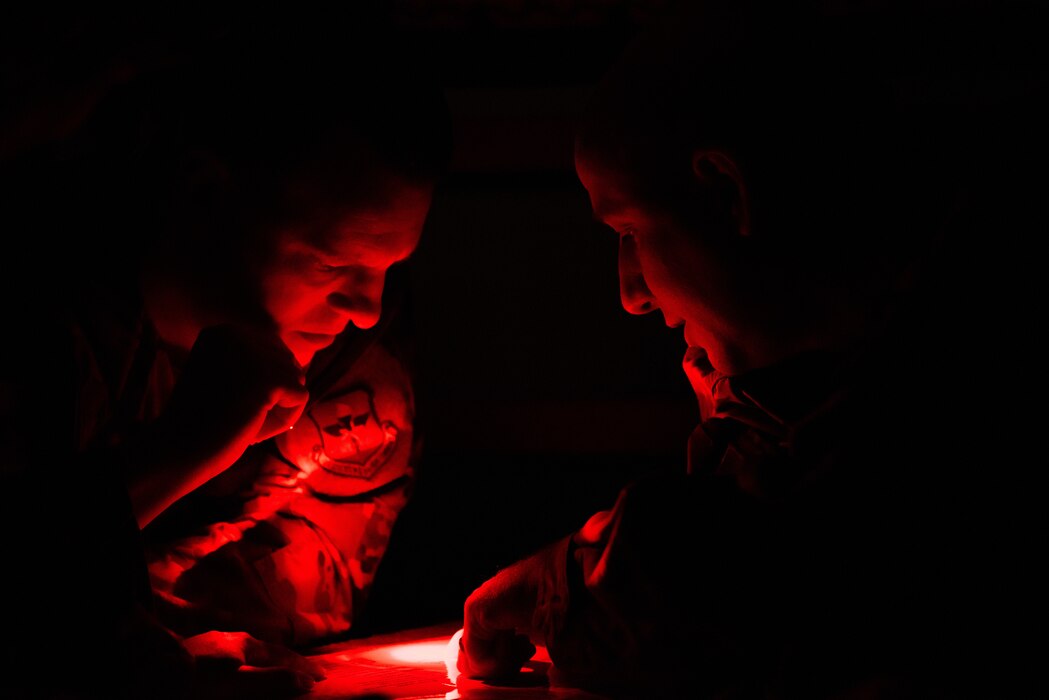 U.S. Air Force Col. Matthew Reilman, 17th Training Wing commander, and Tech. Sgt. Aaron January, 17th Training Wing protocol superintendent, collaborate to complete in a challenge of the feathers contest during the Bazaar of Falcons event, Goodfellow Air Force Base, Texas, Aug. 26, 2022. The Special Warfare Training Wing challenged participants to locate information on a map while in a simulated high-stress environment. (U.S. Air Force photo by Senior Airman Michael Bowman)
