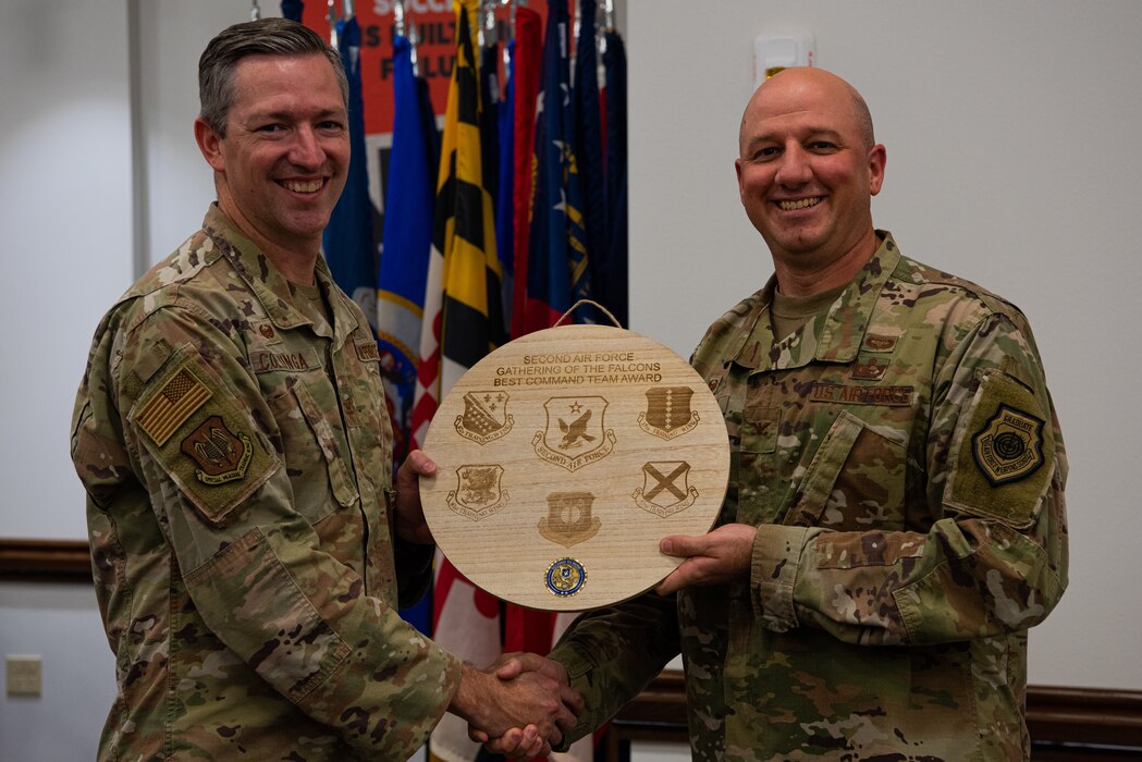 U.S. Air Force Col. Nathan Colunga, Special Warfare Training Wing commander, presents the best command team award to Col. Matthew Reilman, 17th Training Wing commander, following the 2nd annual challenge of the feathers competition during the Bazaar of Falcons event, Goodfellow Air Force Base, Texas, Aug. 26, 2022. The 17th TRW scored the highest across all challenge of the feathers contests, dethroning the reigning champions, the Special Warfare Training Wing. (U.S. Air Force photo by Senior Airman Michael Bowman)