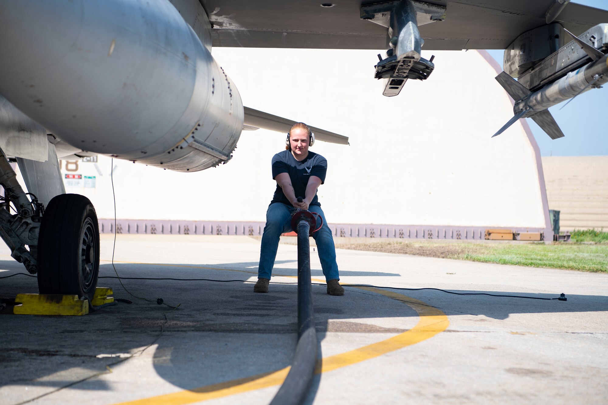 Airman 1st Class Maggie Bennett, 8th Logistics Readiness Squadron fuels distribution operator, pulls a fuel hose line to an F-16 Fighting Falcon at Kunsan Air Base, Republic of Korea, Aug. 26, 2022. The hose allows fuel operators to fuel an aircraft at their parked locations or right before takeoff to help quickly launch jets. (U.S. Air Force photo by Staff Sgt. Sadie Colbert)