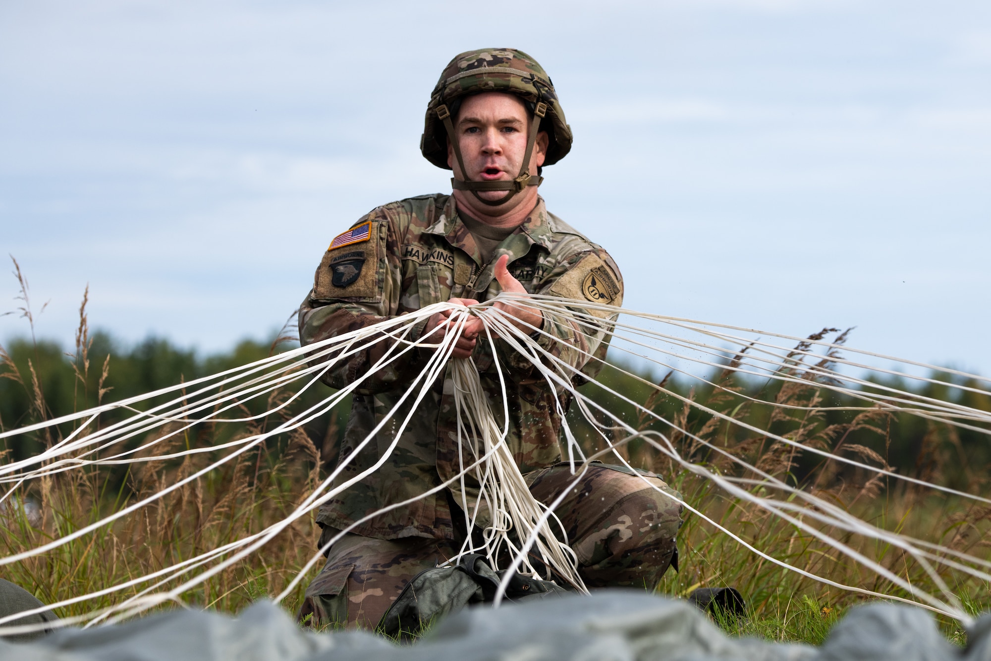 A soldier recovers his parachute after airborne operations.