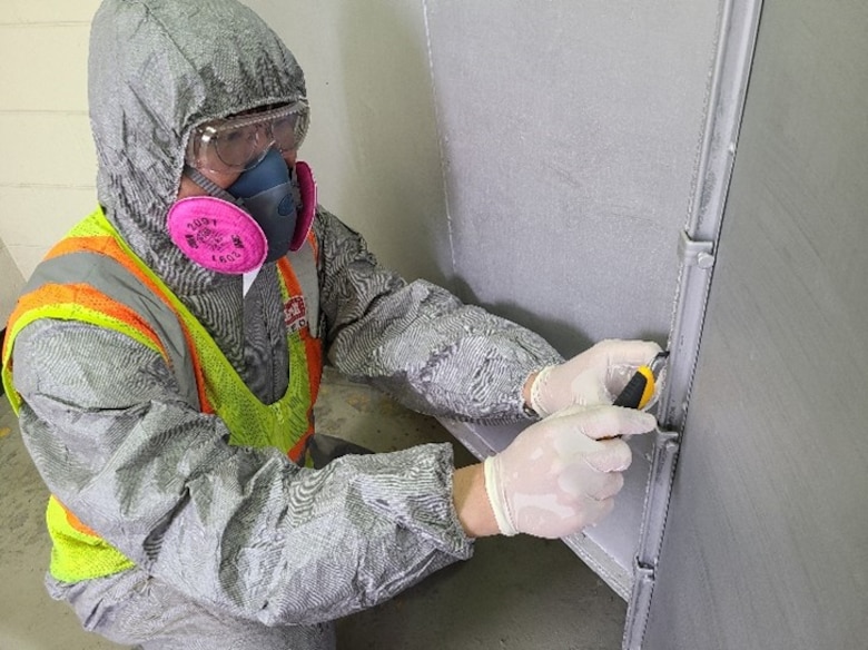 Kim Kyong-ho, U.S. Army Corps of Engineers Far East District Geotechnical Branch chemist, takes a suspected asbestos sample from the gasket used for the duck system in Gwangju Air Base, June 2002. In FED’s asbestos lab, experts analyze asbestos building materials and air samples for worker protection and environmental indoor air quality. (U.S. Army photo by U.S. Army Corps of Engineers Far East District)