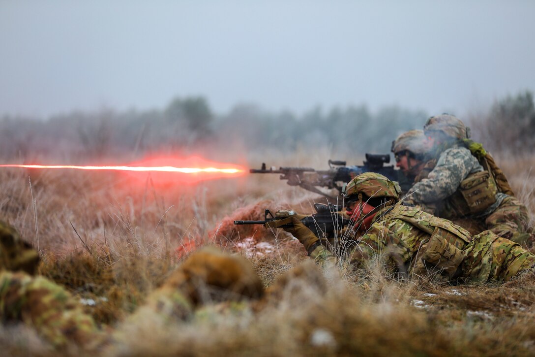 Soldiers fire weapons during an exercise.