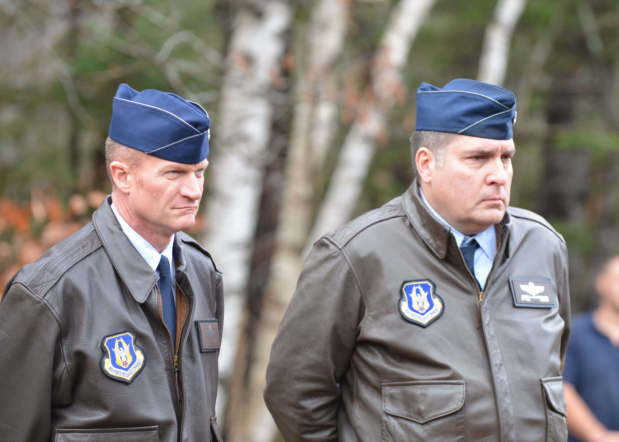 Airman stand solemnly at a funeral.