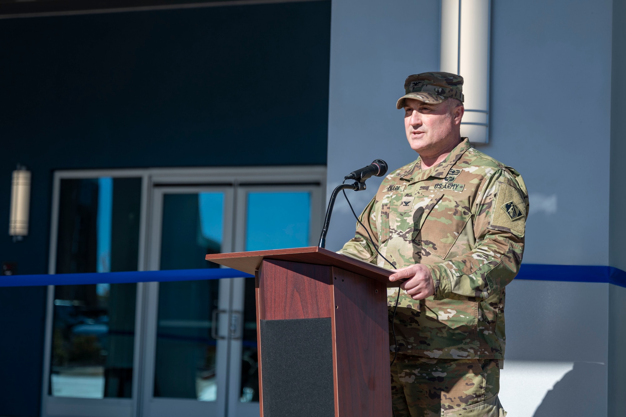 A man in uniform gives a speech while standing at a podium