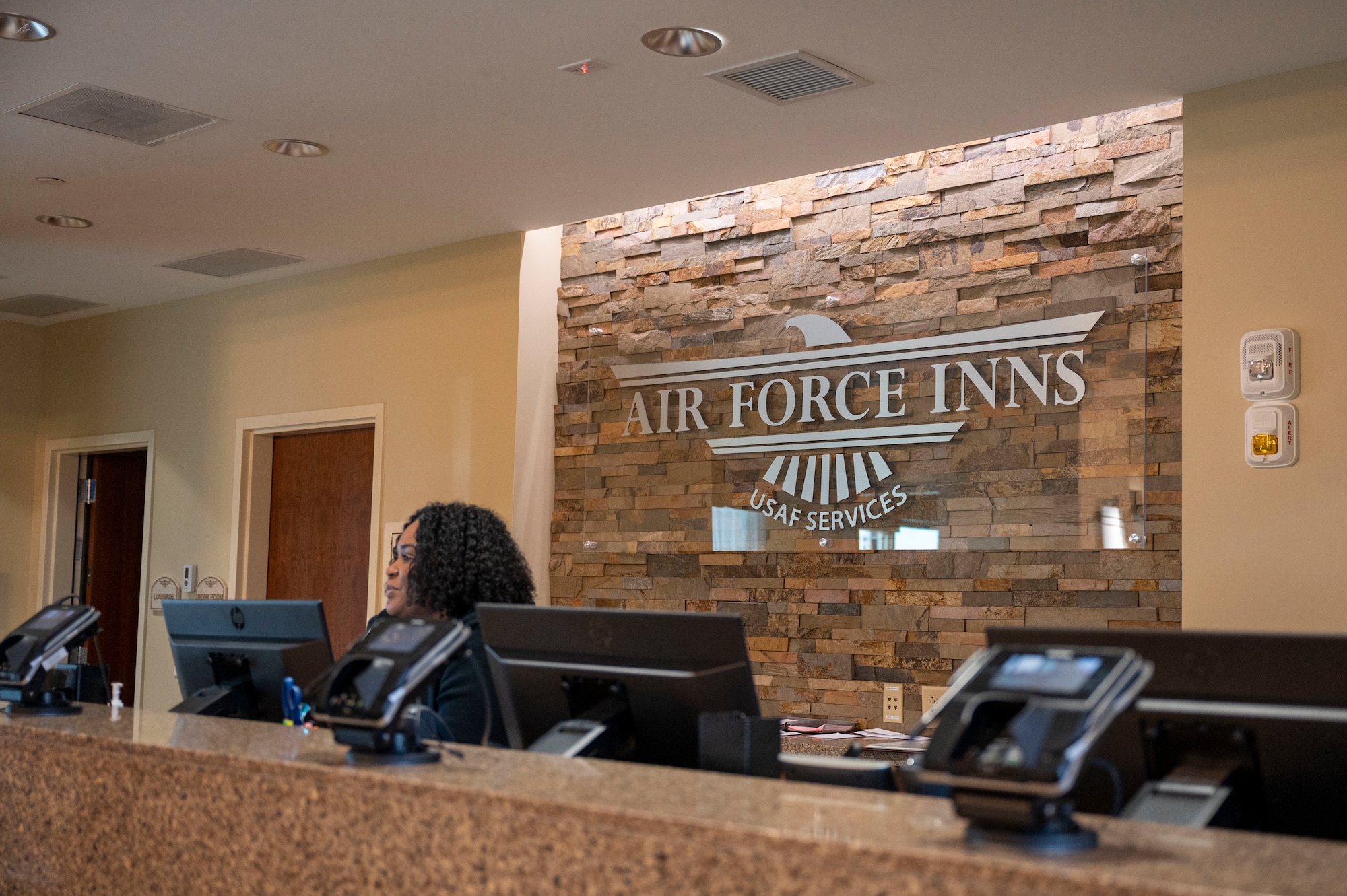 A hotel receptionist greets people during a tour