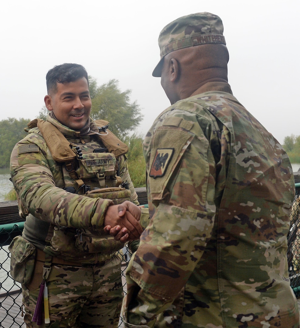 A Texas Guardsmen, left, assigned to Operation Lone Star receives a recognition coin from Senior Enlisted Advisor Tony L. Whitehead, the senior enlisted advisor for the chief, National Guard Bureau, for his outstanding work and dedication to the border mission.