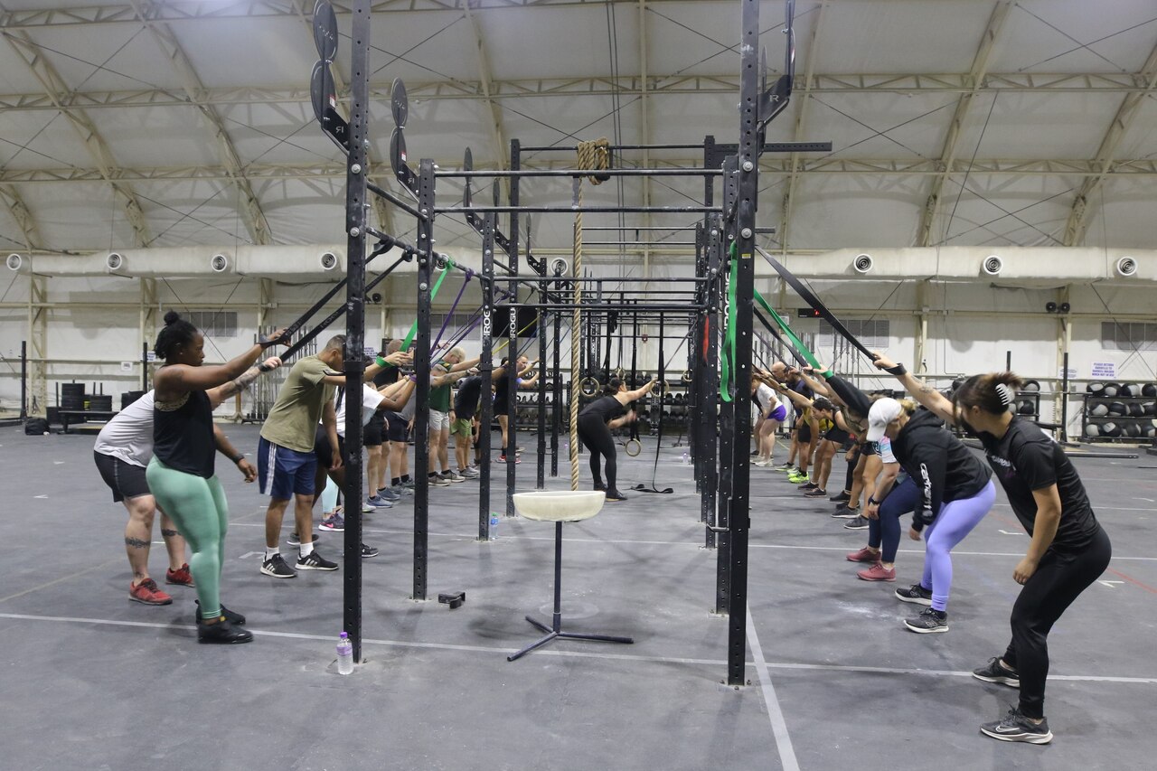 A group of people work out on either side of a large fitness structure.