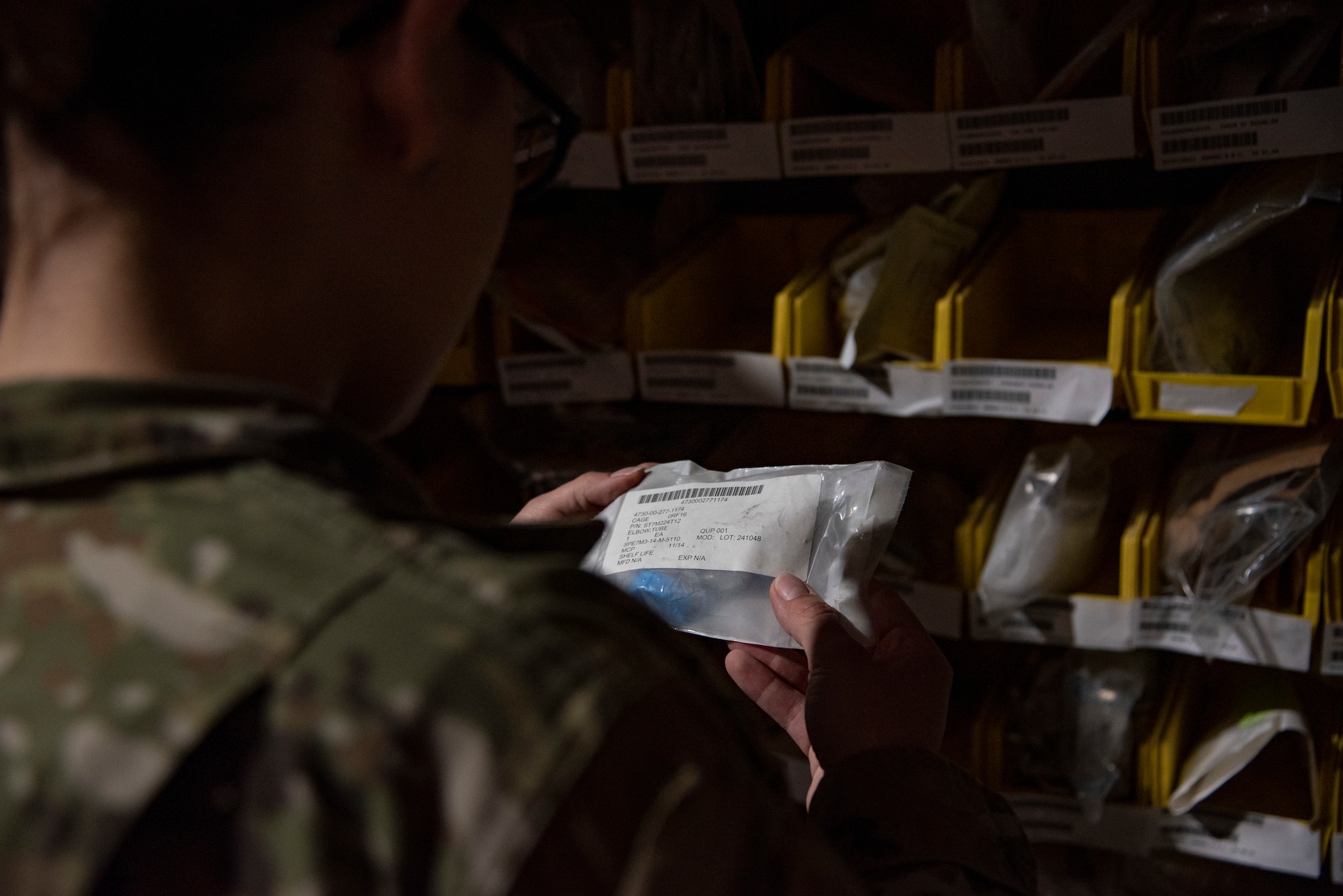 Senior Airman Deanna Juul, a Journeyman with the 332d Expeditionary Logistics Readiness Squadron, Aircraft Parts Store, retrieves parts in a warehouse at an undisclosed location, Southwest Asia, Nov. 11, 2022. The APS provides parts and tools for all maintenance agencies on base. (U.S. Air Force photo by: Tech. Sgt. Jim Bentley)