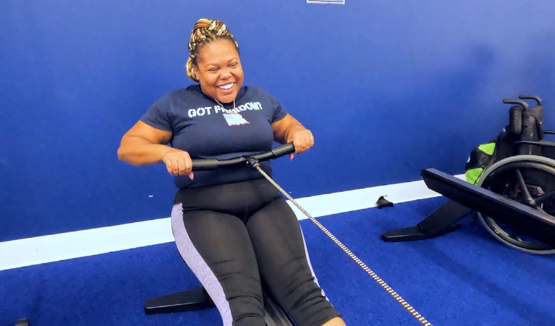 An RSM smiles while rowing on an erg.