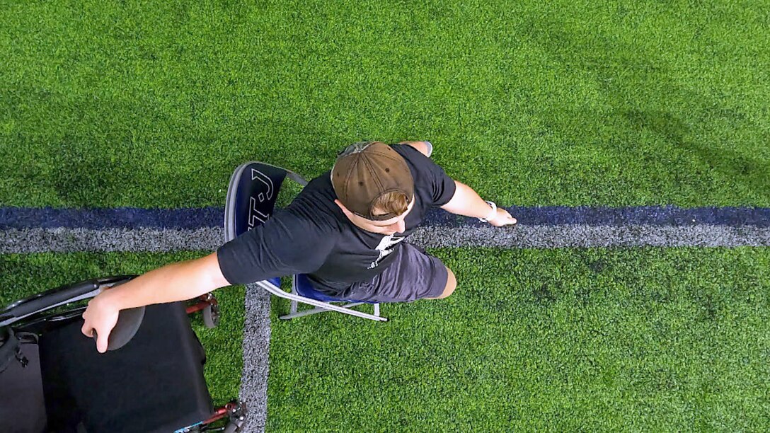 An RSM is seen from above throwing discus while seated.