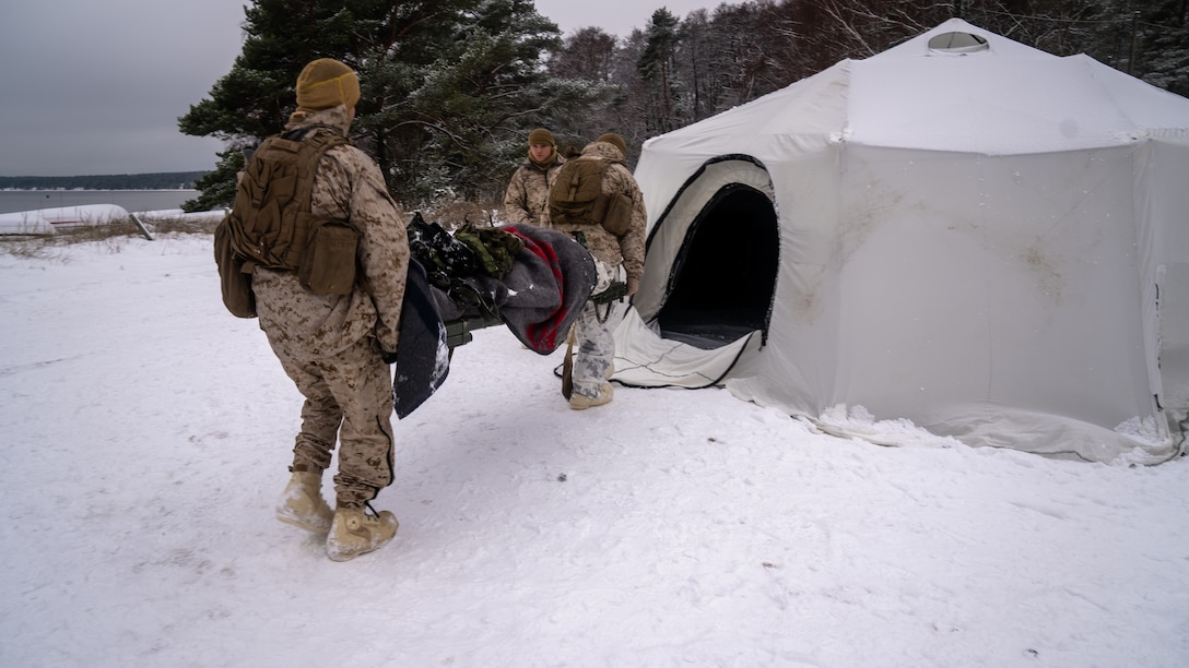 U.S. Marine Corps Cpl. Alex Gracia and Cpl. Ethan Cameron, motor transport operators with Combat Logistics Battalion 6 (CLB-6), carry a simulated wounded Finnish soldier to medical care during exercise Freezing Winds 22 in Hanko, Finland, Nov. 27, 2022.Task Force Red Cloud, headquartered by elements of CLB-6, is deployed to Finland in support of Exercises SYD 2022 and Freezing Winds 2022 to enhance U.S. and Finnish select interdependence in the maritime domain; solidify bilateral maritime maneuver within the Finnish littoral environment; and foster strong relationships between U.S. Marine Corps and Finnish Defense Force sustainment units. (U.S. Marine Corps Photo by Lance Cpl. Maxwell Cook)