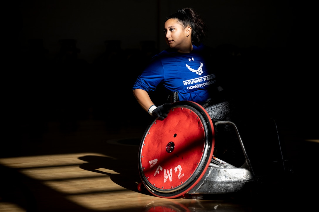 An RSM is highlighted by sun shining through a gym window while playing wheelchair basketball.