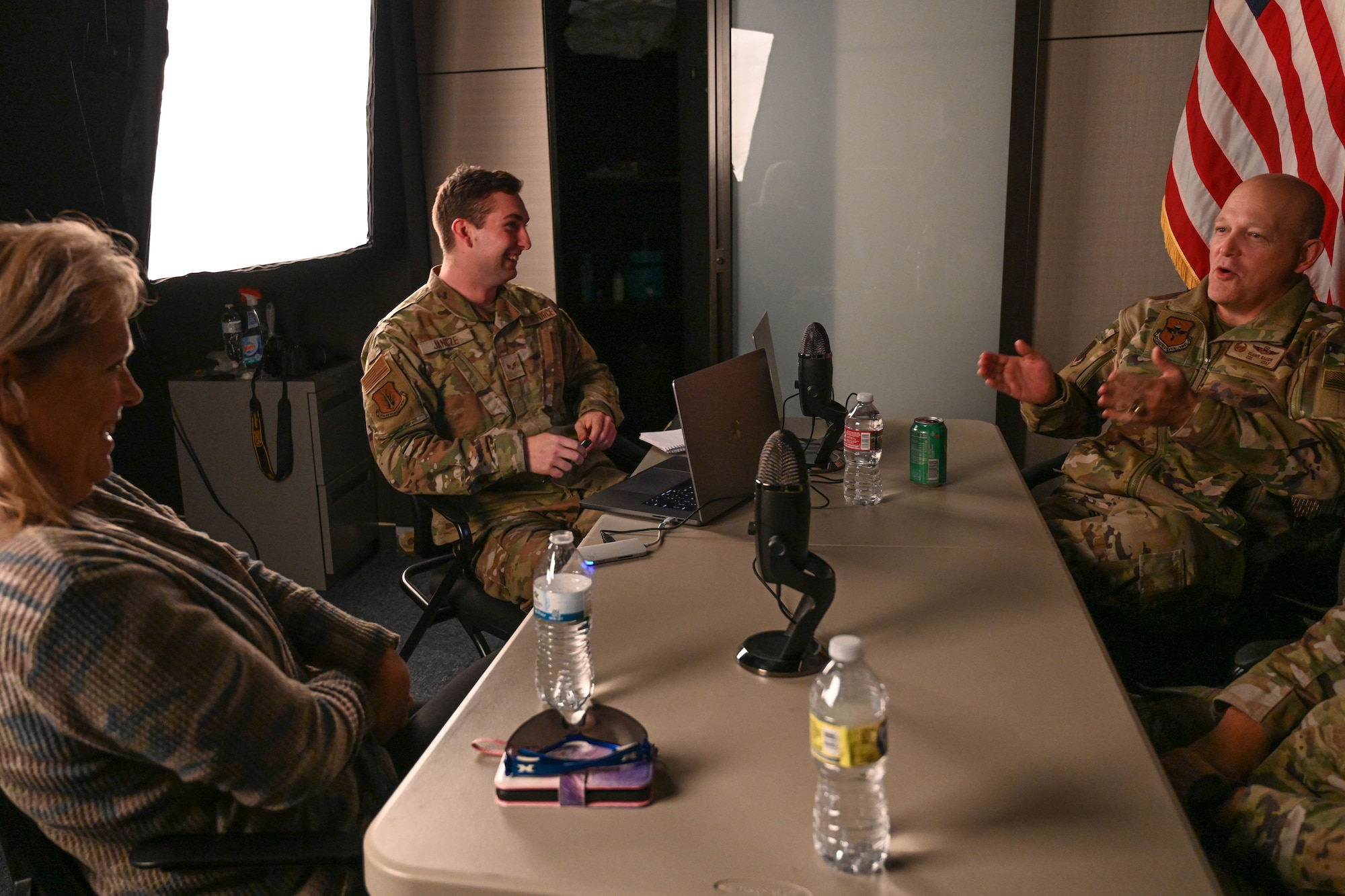 From left, Gail Hargis, 97th Air Mobility Wing (AMW) chief of protocol, and Senior Airman Trenton Jancze, 97th AMW public affairs journeyman, react to Col. Blaine Baker, 97th AMW commander, at Altus Air Force Base, Oklahoma, Nov. 29, 2022. With the podcast’s core topic being leadership, the team has been able to dissect how each of their guests has improved professionally and personally throughout their life and career. (U.S. Air Force photo by Airman 1st Class Kari Degraffenreed)