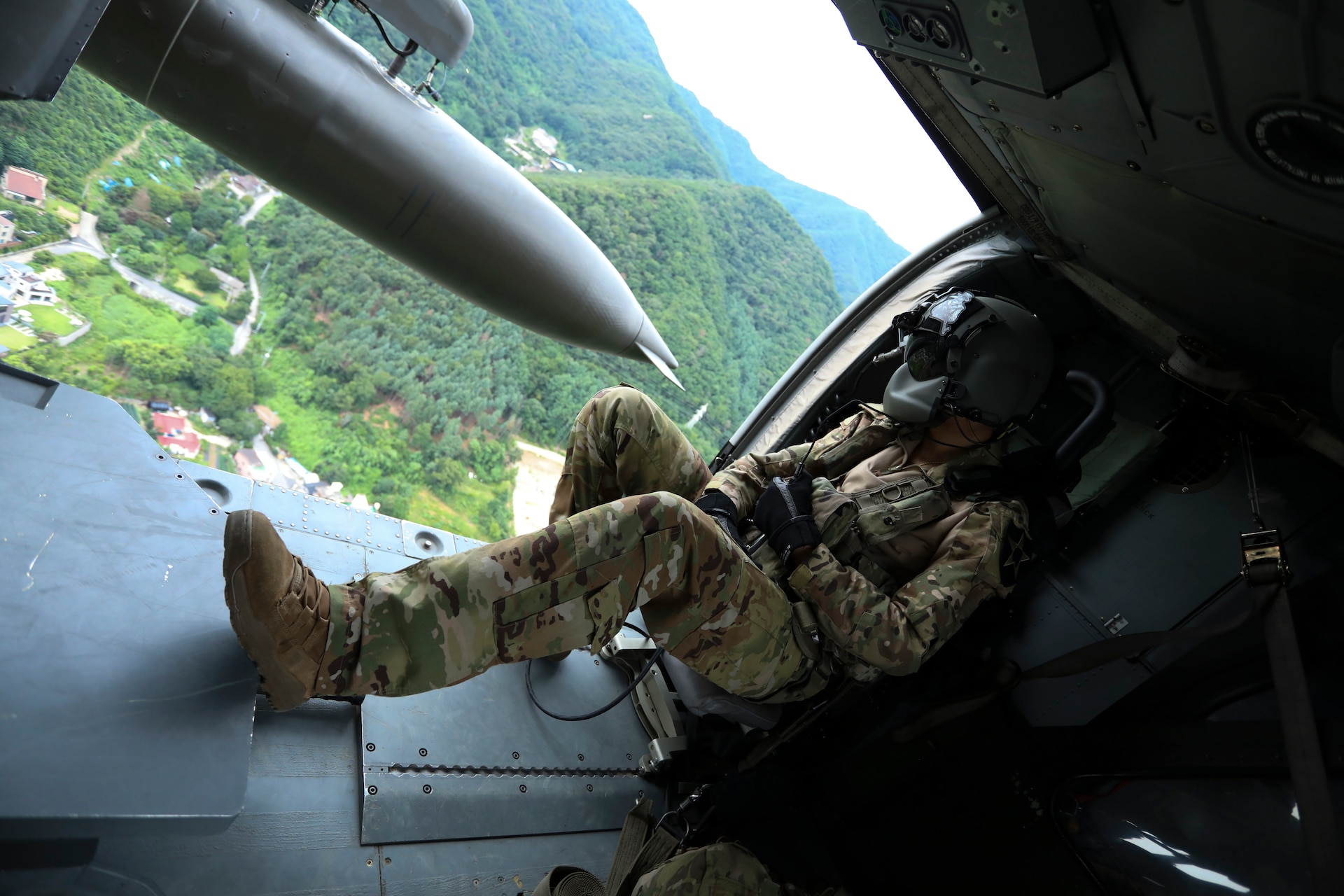Spc. Prentice Urban, a UH-60 Helicopter Repairer and Crew Chief from Charlie Company, 3-2 General Support Aviation Battalion, 2nd Combat Aviation Brigade, 2nd Infantry Division, observes flight path for any obstructions, September 1, 2022, Camp Humphreys, Republic of Korea. Urban's position as a crew chief is to assist the pilots during the flight ensuring proper operations. (U.S. Army photo by Sgt. Oscar Toscano)