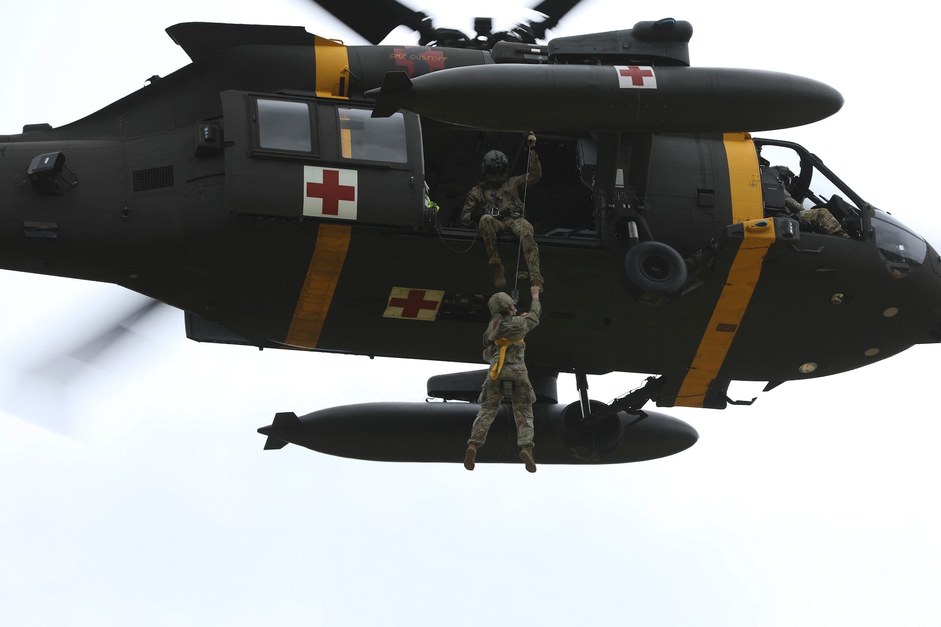 Sgt. Jake Mellott, verifies the casualty is safely hoisted to the HH-60M MEDEVAC Helicopter while hovering overhead, September 1, 2022, Korea Combat Training Center, Republic of Korea. The hoist is used for evacuations where the aircraft cannot land to pick up a casualty in a timely manner. (U.S. Army photo by Sgt. Oscar Toscano)