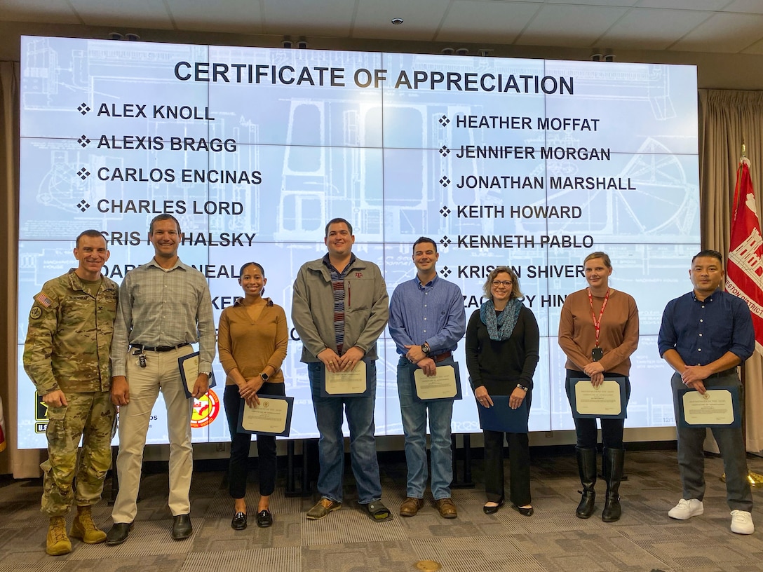 U.S. Army Corps of Engineers Galveston District Commander Col. Rhett Blackmon (left) awards several district employees with a certificate of appreciation for their efforts in preparing and executing several public open houses for the Port Arthur and Orange County projects.