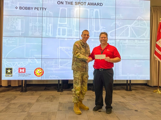 U.S. Army Corps of Engineers (USACE) Galveston District Commander Col. Rhett Blackmon (left) gives Strategic Outreach Specialist Bobby Petty an "On-the-Spot" award for his his outstanding efforts in the Mega Projects Division.