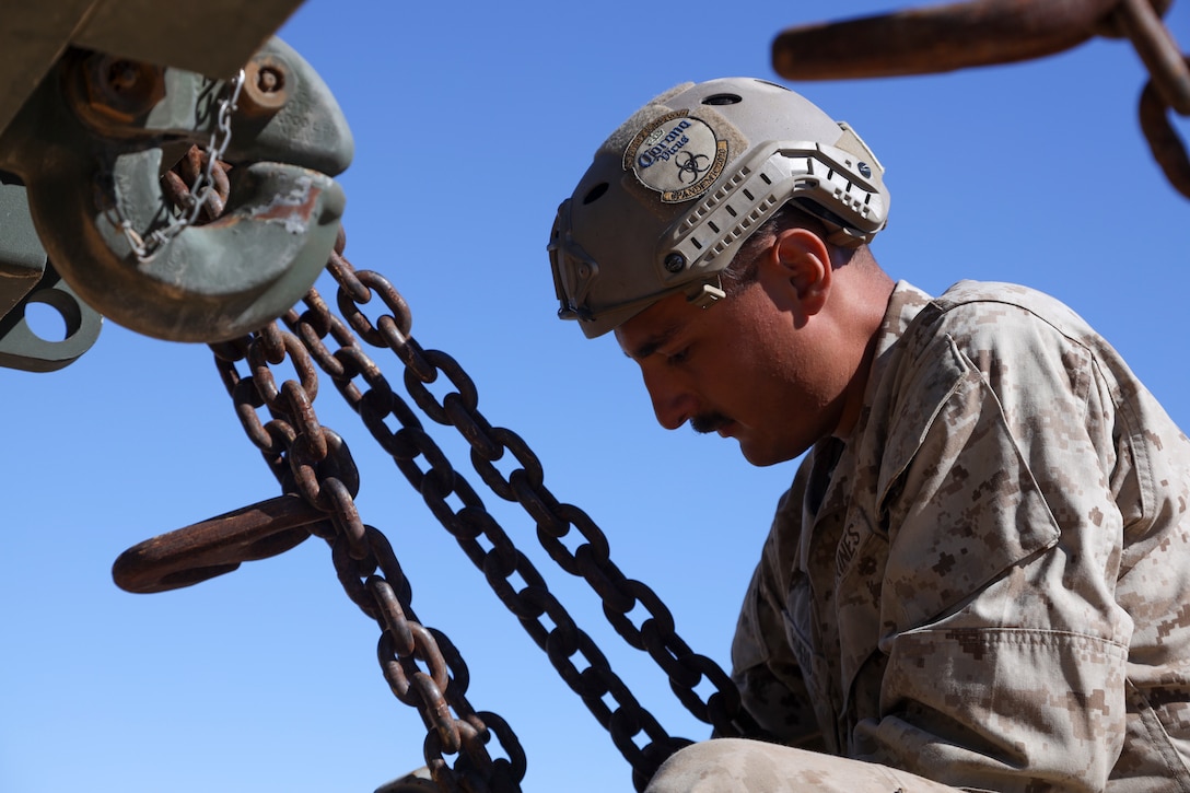 U.S. Marine Corps Cpl. Tristan Romero, Landing Support Technician, 2nd Landing Support Battalion, 2nd Marine Logistics Group, secures a vehicle onto a train car during railroad operations amid Weapons and Tactics Instructor (WTI) Course 1-23 near Glamis, California, Nov. 4, 2022.