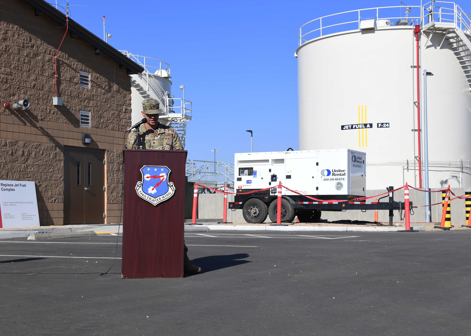 A man wearing a military uniform stands behind a podium reading a speech.