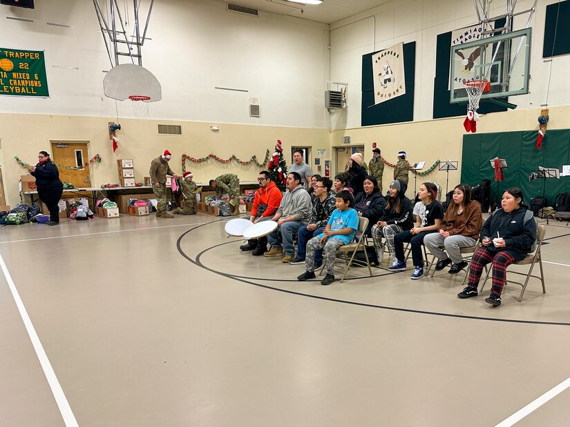 Community members share a traditional Inupiaq song with volunteers supporting Operation Santa Claus at the Trapper School in Nuiqsut, Alaska, Nov. 29, 2022. Operation Santa Claus is the Alaska National Guard’s yearly community relations and support program that provides gifts to children in remote communities across the state. In partnership with the Salvation Army, Santa, Mrs. Claus and more than three dozen elves delivered 1,420 pounds of gifts, backpacks, hygiene supplies, and books to 191 children in Nuiqsut.