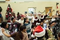 Santa and Mrs. Claus join community members in a traditional Inupiat dance during Operation Santa Claus at the Trapper School in Nuiqsut, Alaska, Nov. 29, 2022. Operation Santa Claus is the Alaska National Guard’s yearly community relations and support program that provides gifts to children in remote communities across the state. In partnership with the Salvation Army, Santa, Mrs. Claus and more than three dozen elves delivered 1,420 pounds of gifts, backpacks, hygiene supplies, and books to 191 children in Nuiqsut.