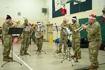 Musicians with the 11th Airborne Division Band play seasonal tunes and Christmas carols during the Operation Santa Claus celebration at the Trapper School in Nuiqsut, Alaska, Nov. 29, 2022. Santa, Mrs. Claus and more than three dozen elves from the Alaska Air and Army National Guard partnered with the Salvation Army to deliver 1,420 pounds of gifts, hygiene supplies, and books to 191 children. Celebrating 67 years of Operation Santa Claus, a 176th Wing, Alaska Air National Guard HC-130J Combat King II aircraft served as Santa's sleigh, delivering tidings of good cheer to the North Slope Borough community.