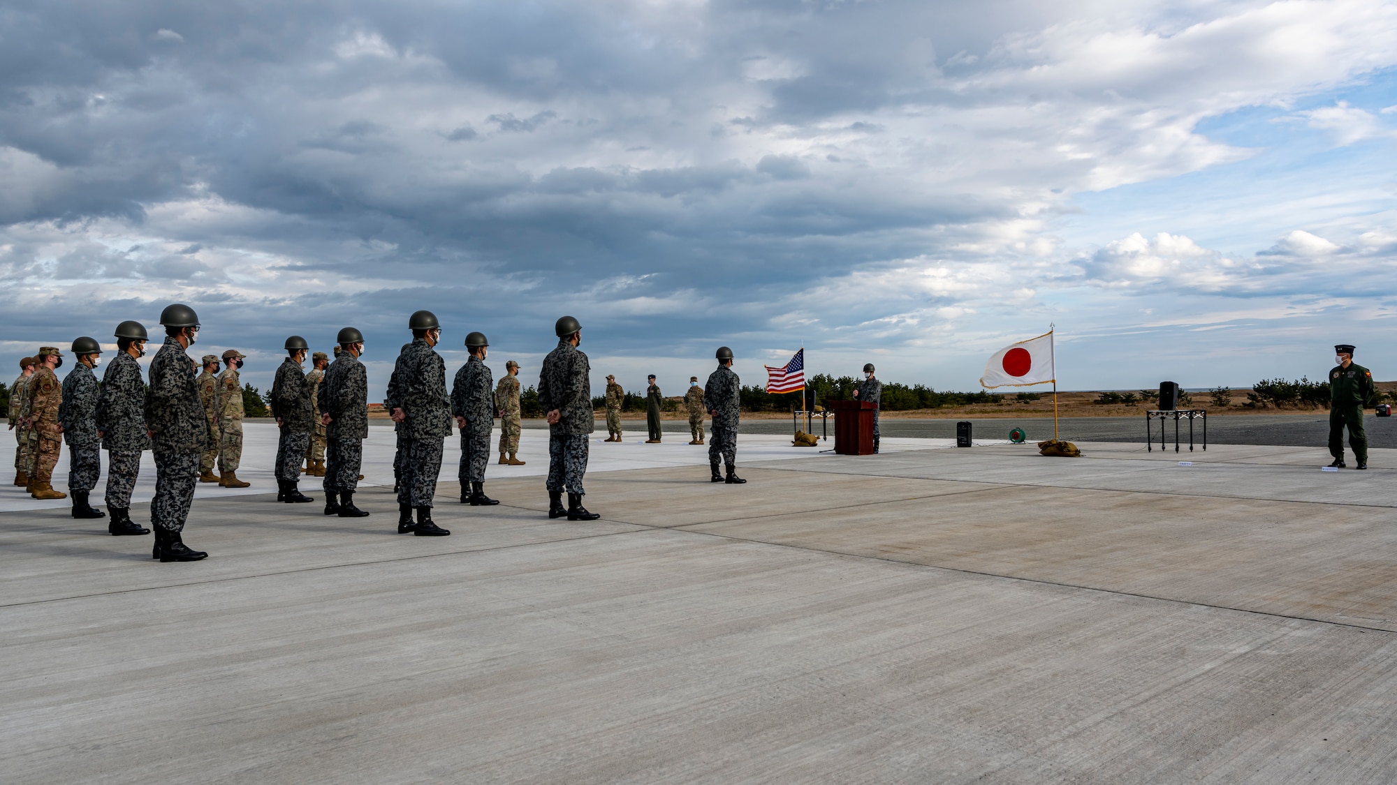 U.S. Air Force and Japan Air Self-Defense Force members, assigned to the 35th Civil Engineer Squadron and the Northern Air Civil Engineering Group, attend a ceremony to commemorate the completion of a bilateral Rapid Airfield Damage Recovery (RADR) pad at Draughon Range near Misawa Air Base, Japan, Nov. 29, 2022.