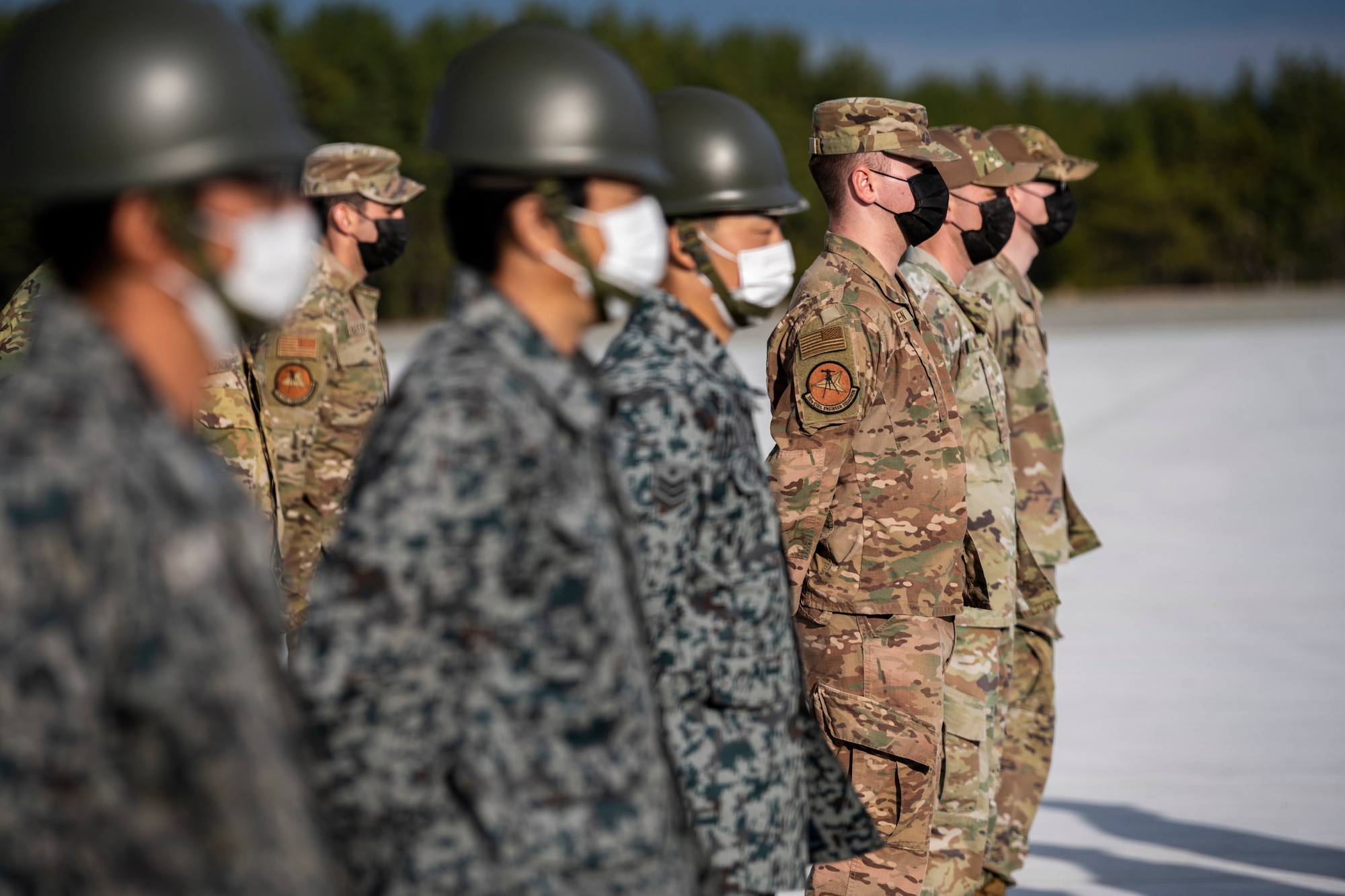 U.S. Air Force and Japan Air Self-Defense Force members, assigned to the 35th Civil Engineer Squadron and the Northern Air Civil Engineering Group, attend a ceremony to commemorate the completion of a bilateral Rapid Airfield Damage Recovery (RADR) pad at Draughon Range near Misawa Air Base, Japan, Nov. 29, 2022.