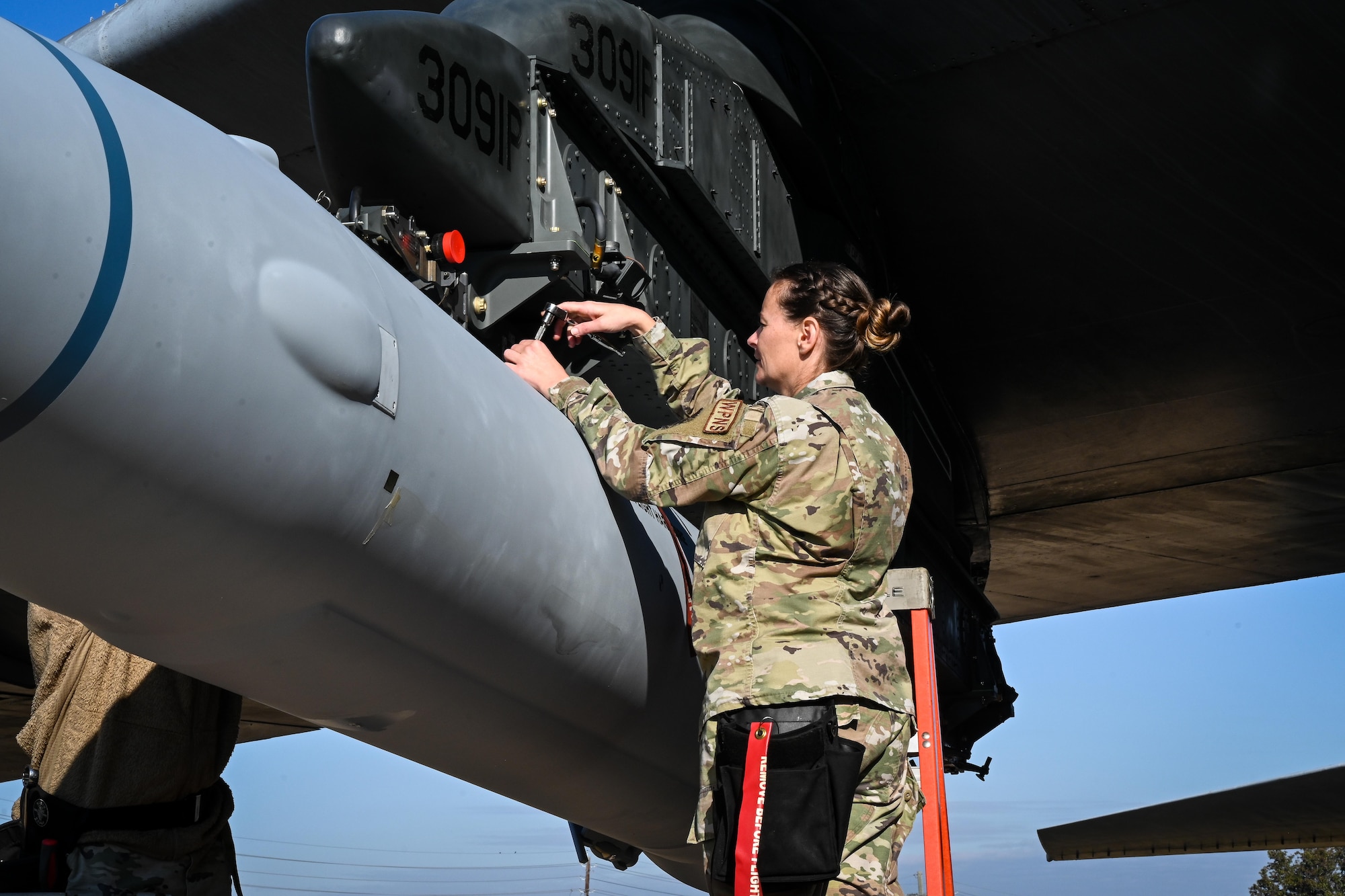 U.S. Air Force Master Sgt. Marcella Philips, 2nd Maintenance Group weapons standardization loading standardization crew chief, tightens bolts to secure the weapon to a B-52H Stratofortress, at Barksdale Air Force Base, Louisiana, Nov. 2, 2022.