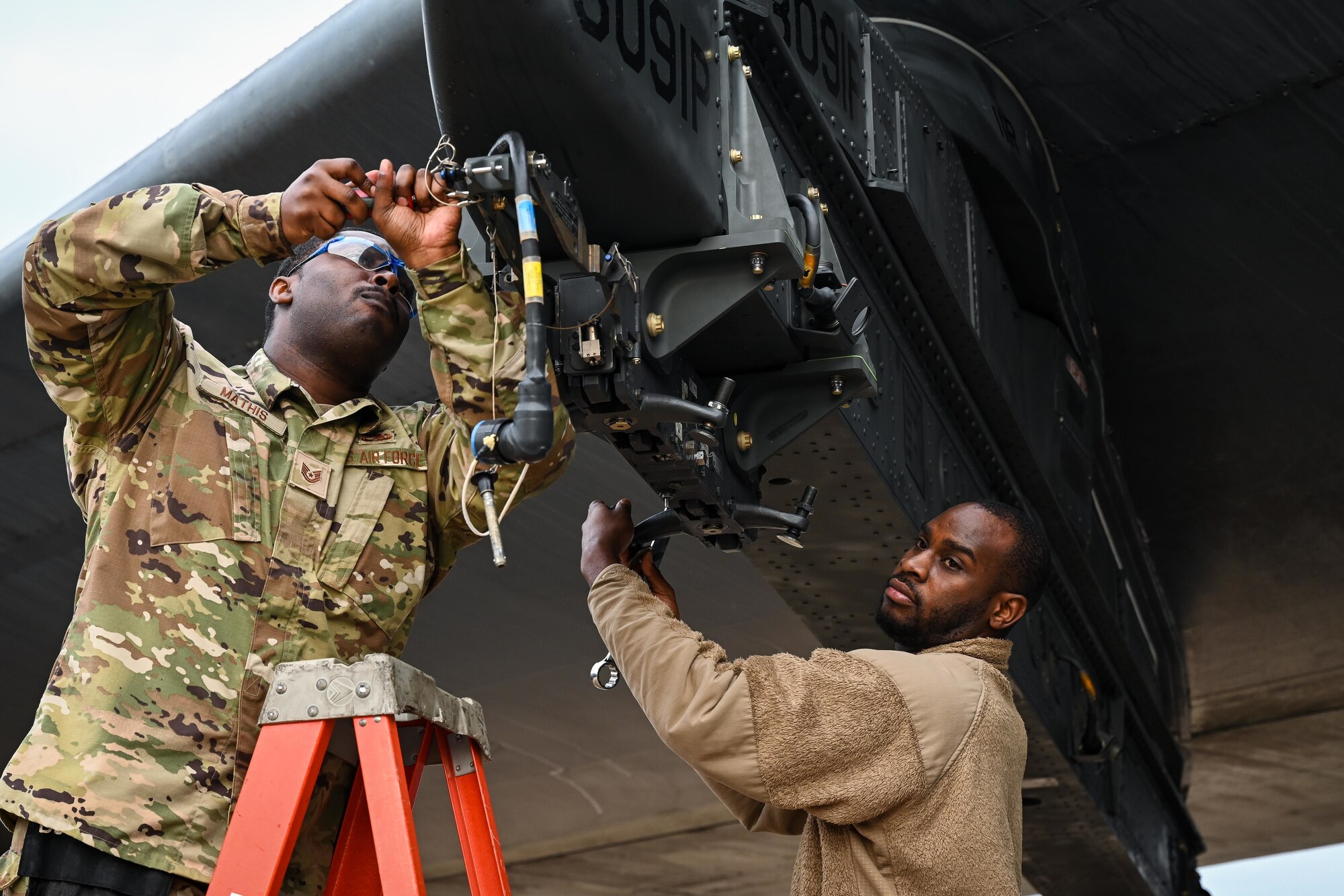 U.S. Air Force Tech Sgt. Charlie Mathis, 2nd Maintenance Group weapons standardization loading standardization crew member, and Tech Sgt. Darrell Stewart, 307th Aircraft Maintenance Squadron loading standardization crew member, prepares a B-52H Stratofortress ejector rack for loading munitions, at Barksdale Air Force Base, Louisiana, Nov. 2, 2022