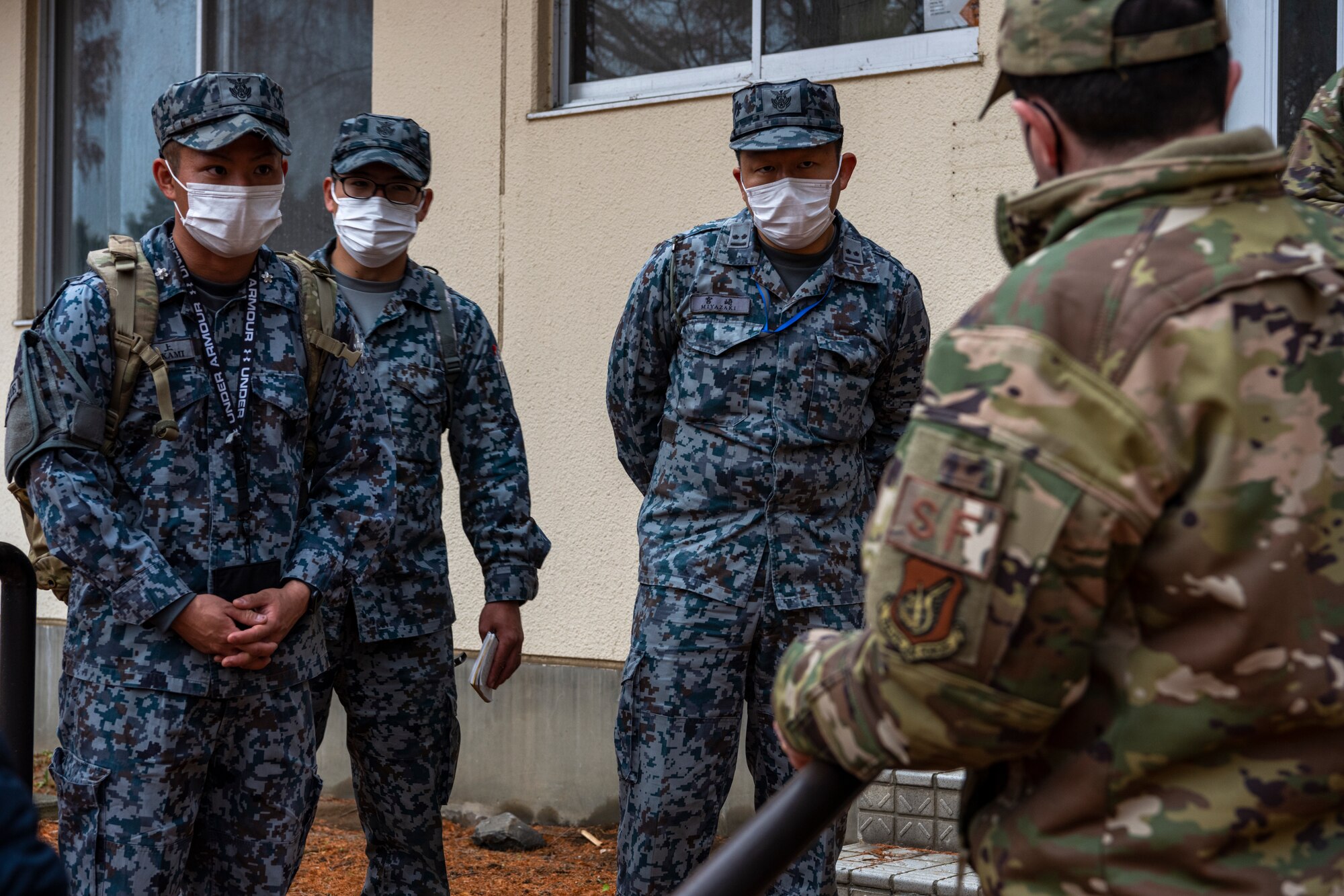 U.S. Air Force and Japan Air Self-Defense Force members work together during a bilateral training event at Misawa Air Base, Japan, Nov. 29, 2022. This multi-day training event allowed JASDF members a chance to see how U.S. Air Force military working dog handlers train their dogs. (U.S. Air Force photo by Senior Airman Antwain Hanks)
