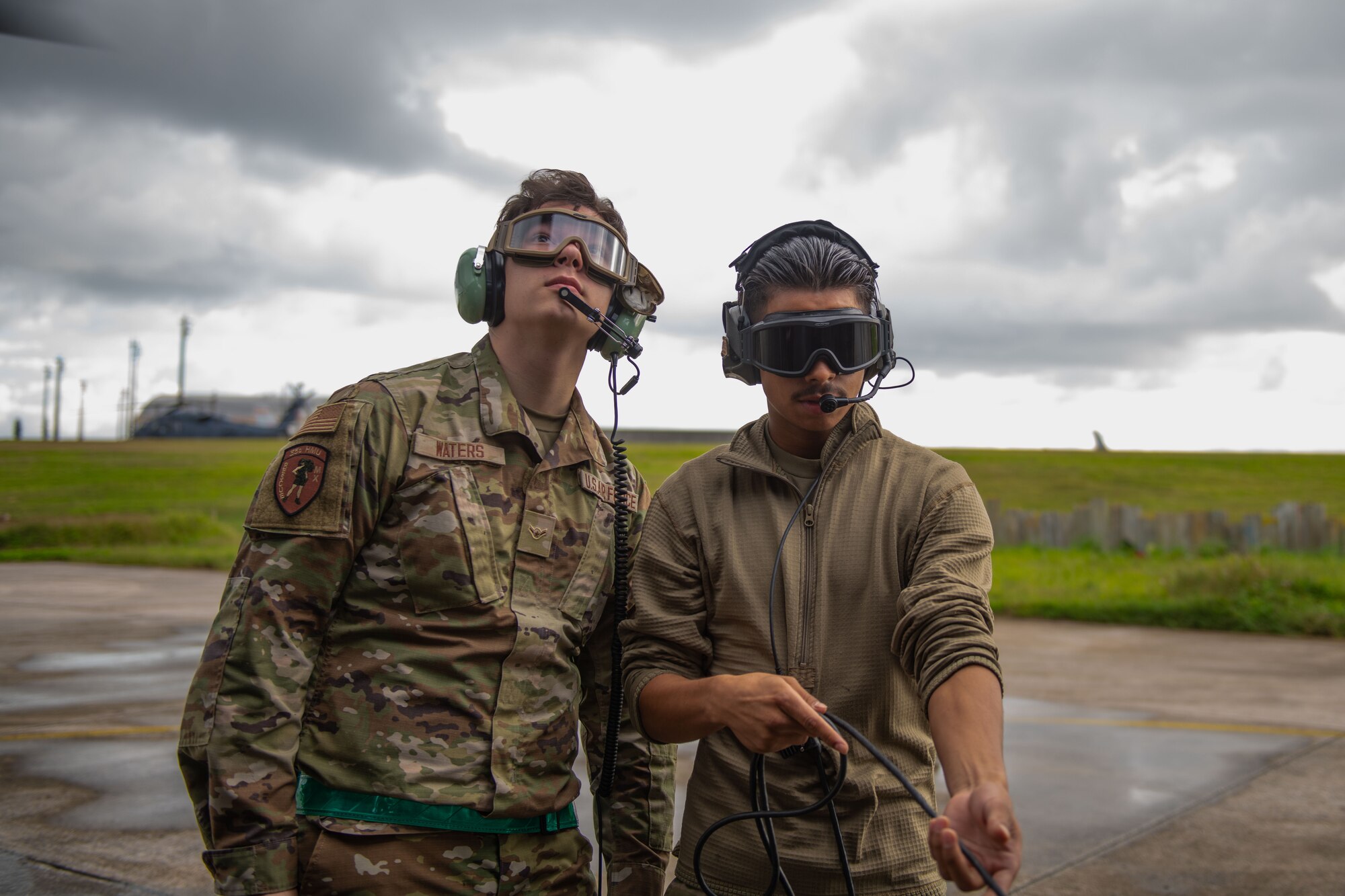 Two airmen prep a helicopter for takeoff
