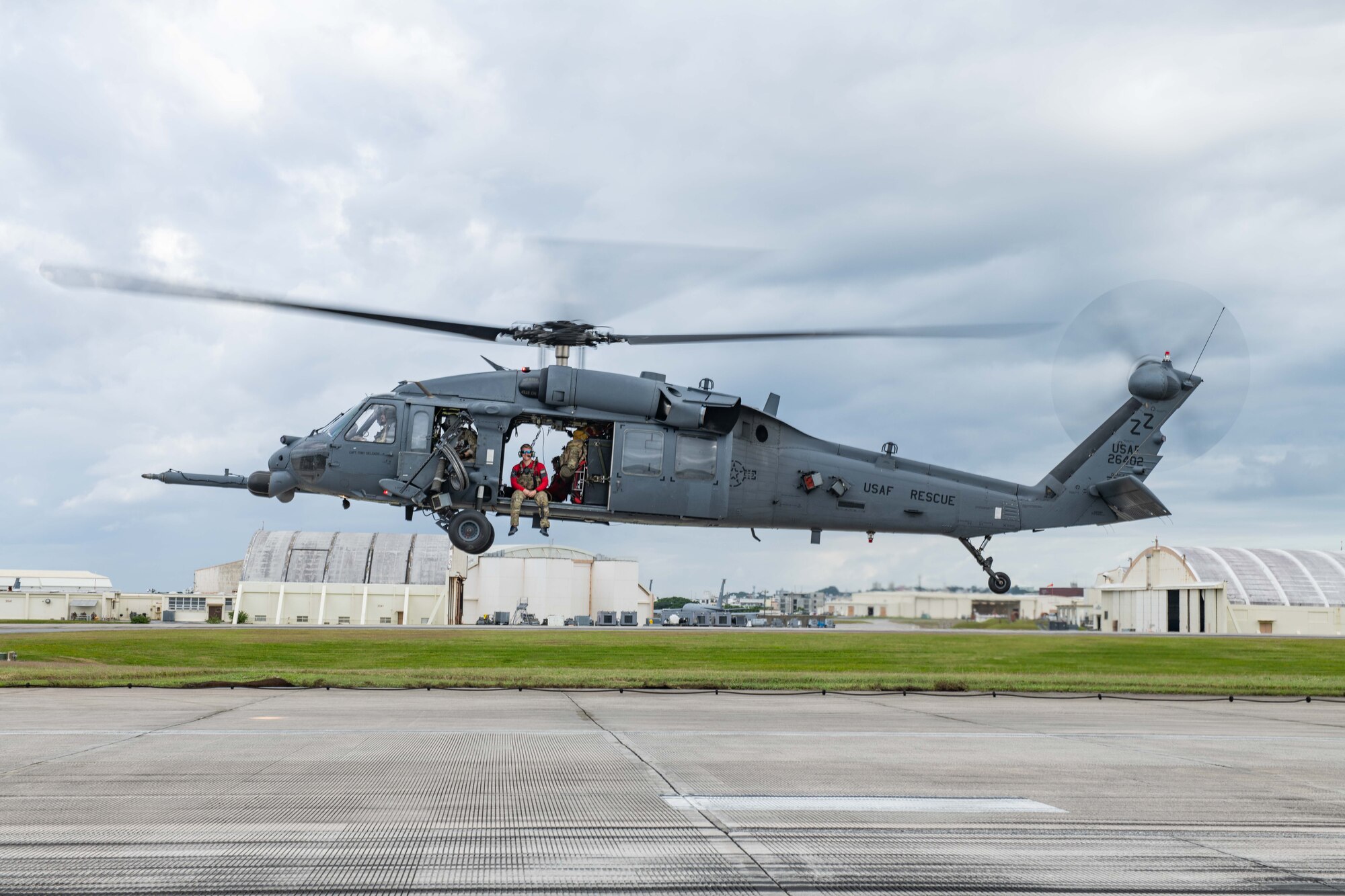 A helicopter hovers over a flight line