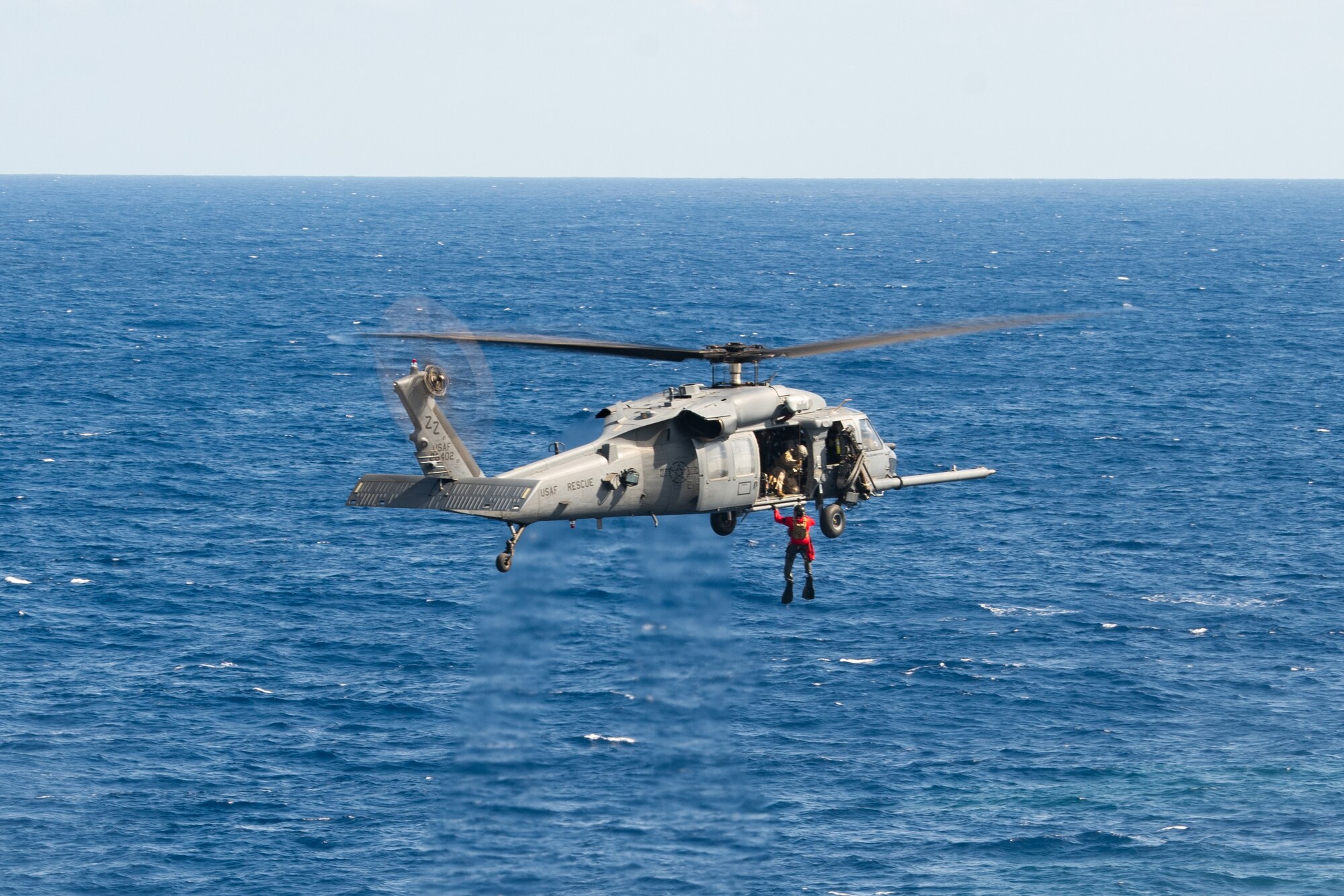 A diver gets hoisted up into a helicopter