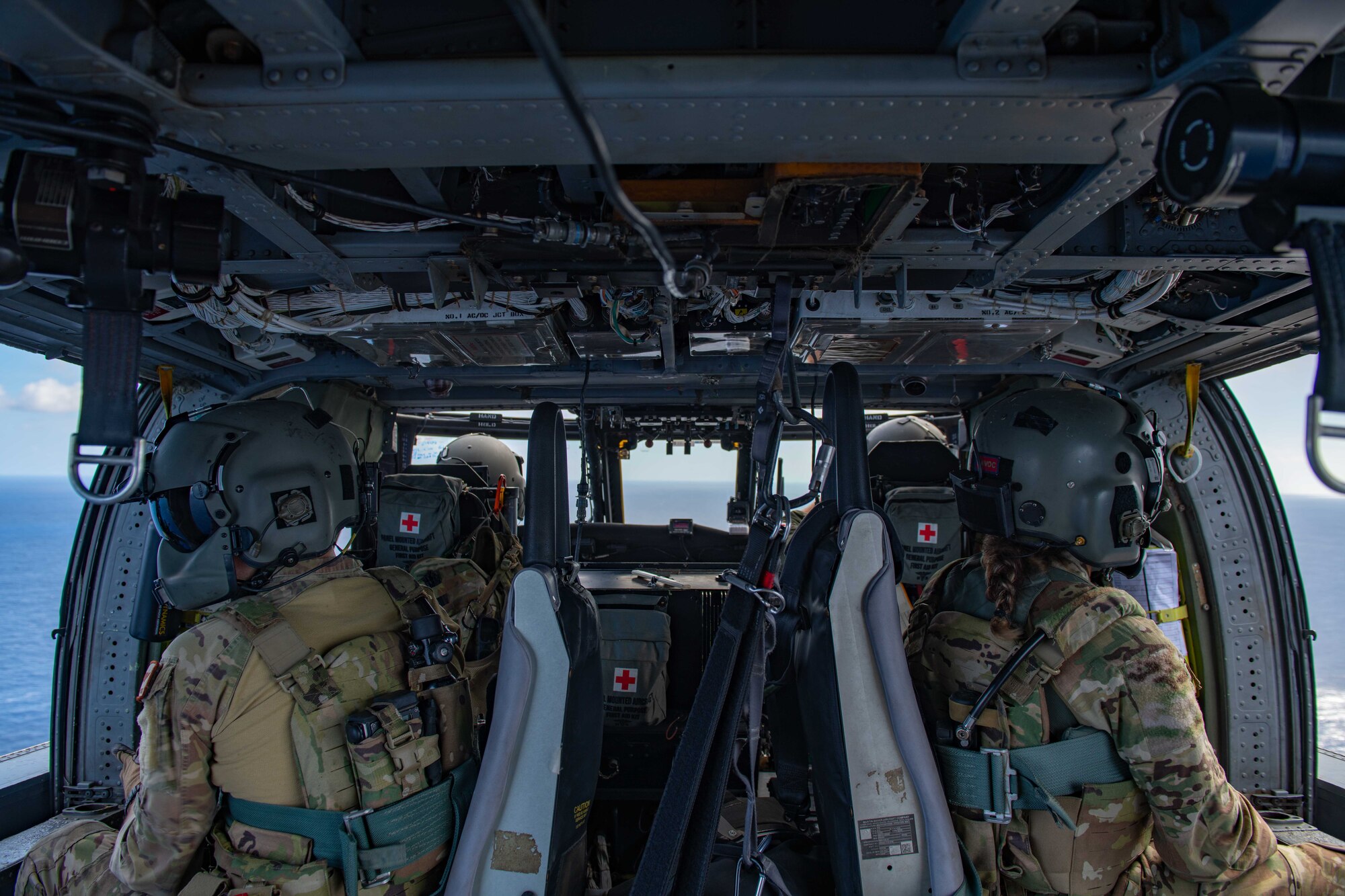 A helicopter crew flies over the ocean