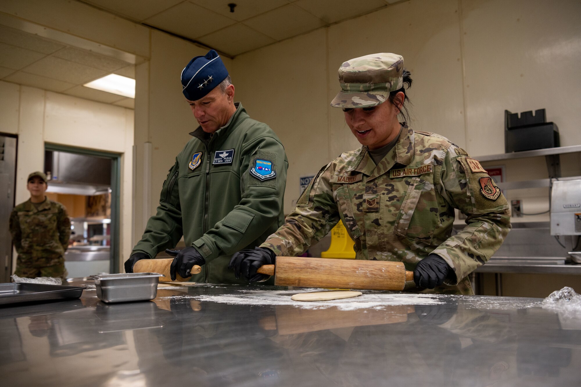 U.S. Air Force Lt. Gen. Scott Pleus, 7th Air Force commander, and Staff Sgt. Deandra Madrid, 51st Force Support Squadron’s Pacific House dining facility manager, roll out Naan dough at the Gingko Tree dining facility on Osan Air Base, Republic of Korea, Nov 30, 2022.