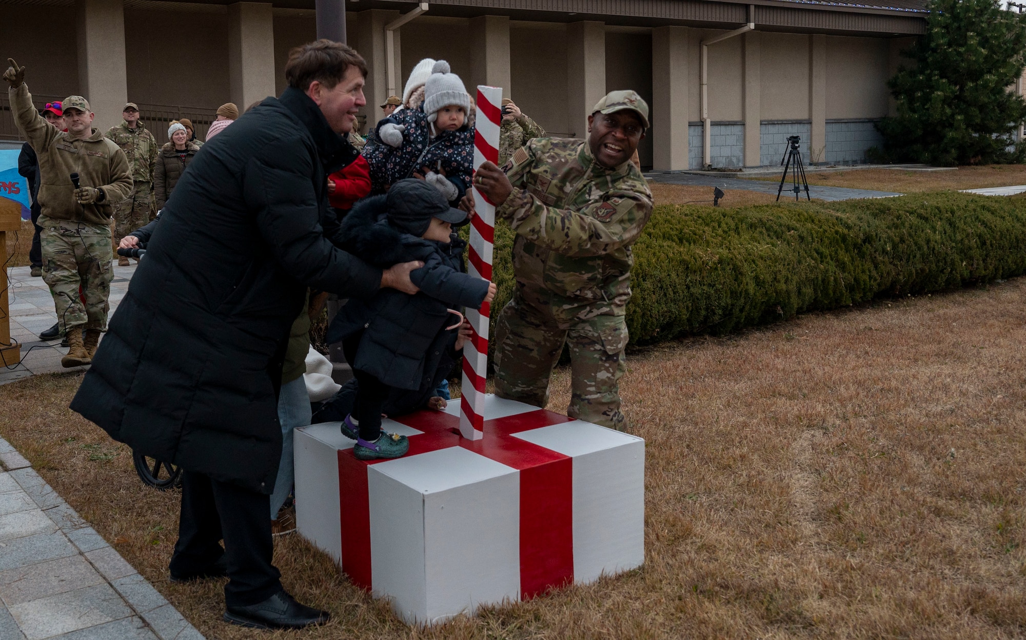 U.S. Air Force Col. Henry R. Jeffress, III, 8th Fighter Wing commander (right) helps Kunsan children turn on the lights at the tree lighting ceremony at Kunsan Air Base, Republic of Korea, Dec. 1, 2022. Due to the ease of travel to the Republic of Korea, Kunsan Airmen dependents often visit the installation over the holiday seasons. (U.S. Air Force photo by Tech. Sgt. Timothy Dischinat)