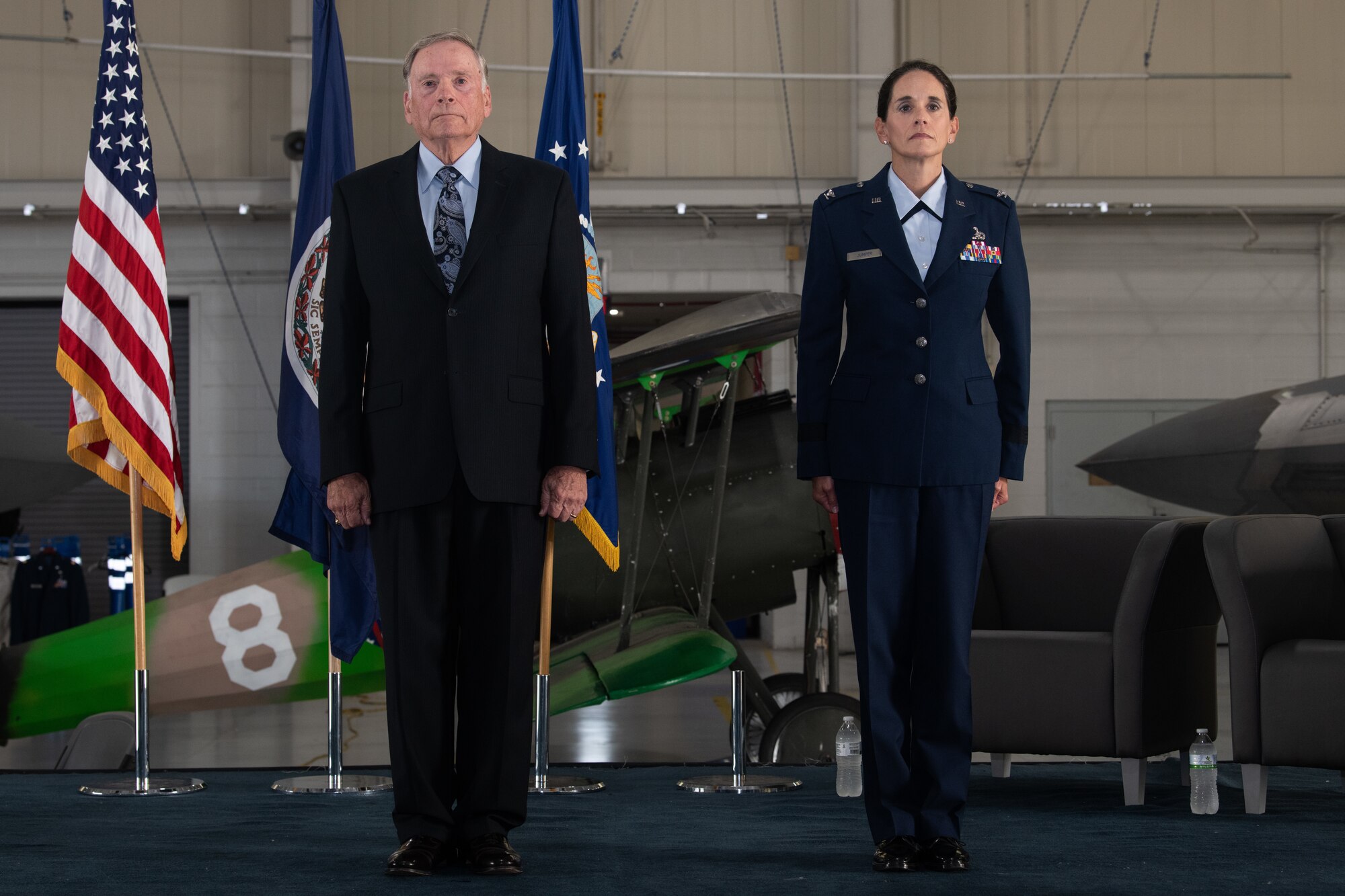 Gen. John P. Jumper and Col. Catherine M. Jumper stand on stage at attention.
