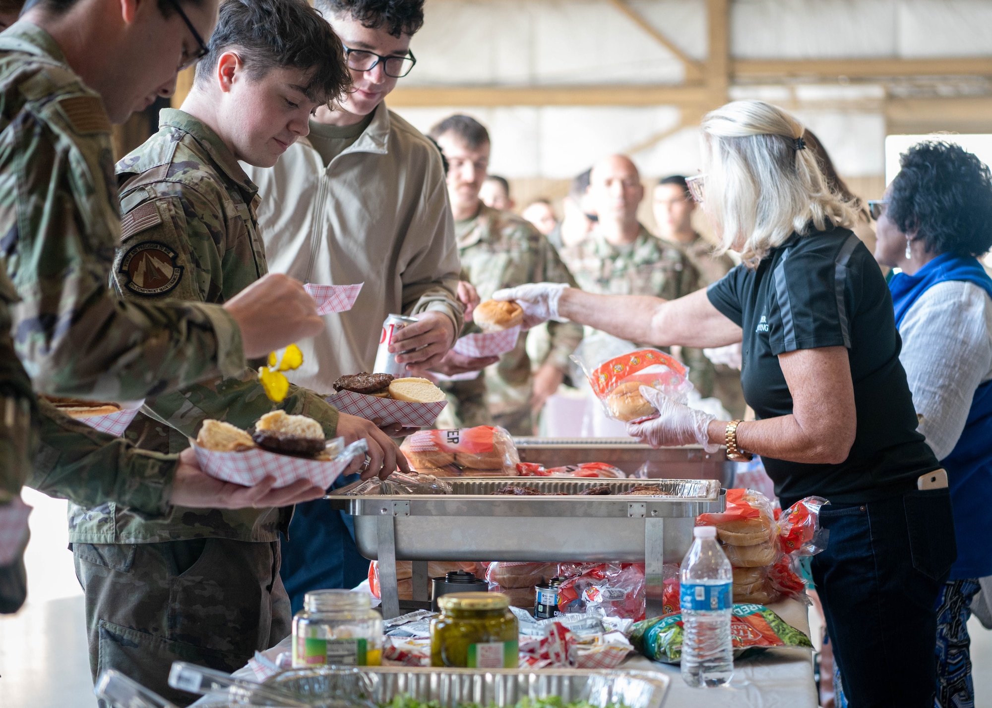 Attendees assemble hotdogs and hamburgers at the Military Appreciation Picnic.