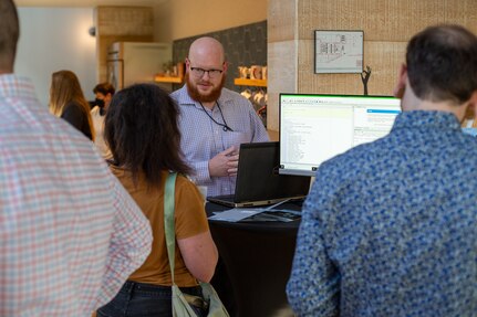 A man stands in front of a computer.