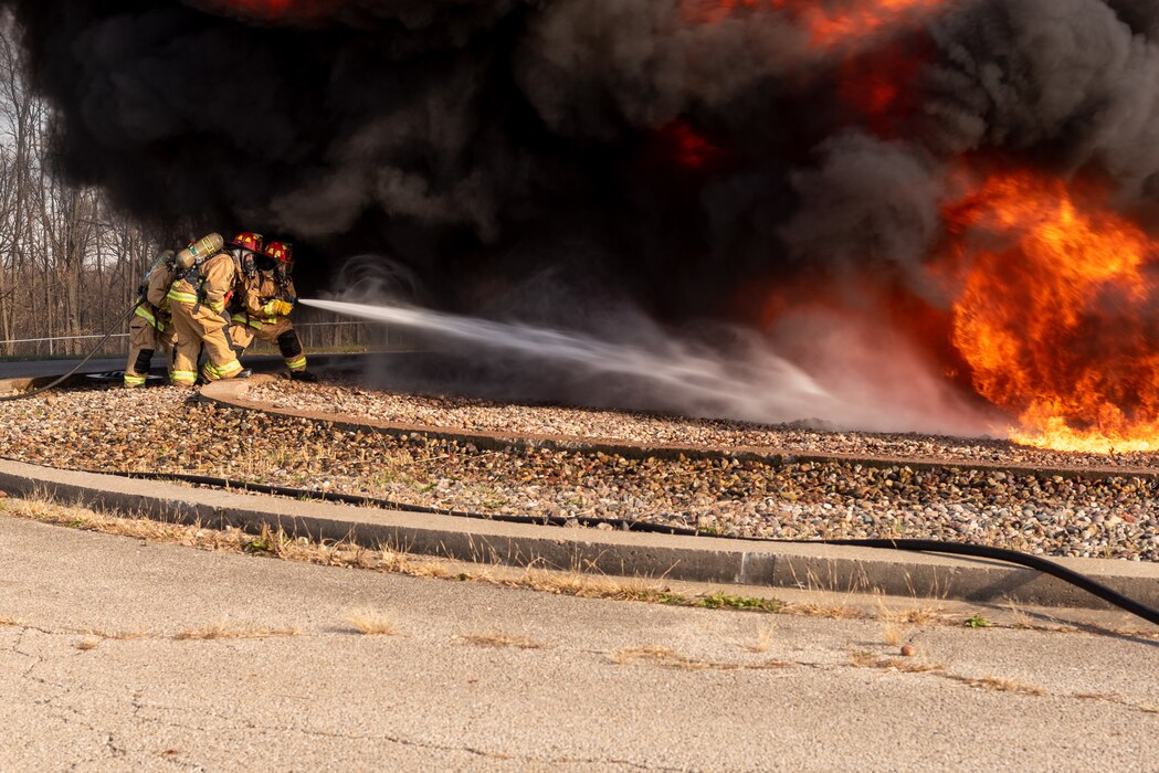 Firefighters extinguishing burn pit.