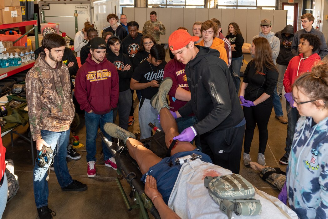 Student applying tourniquet to dummy.