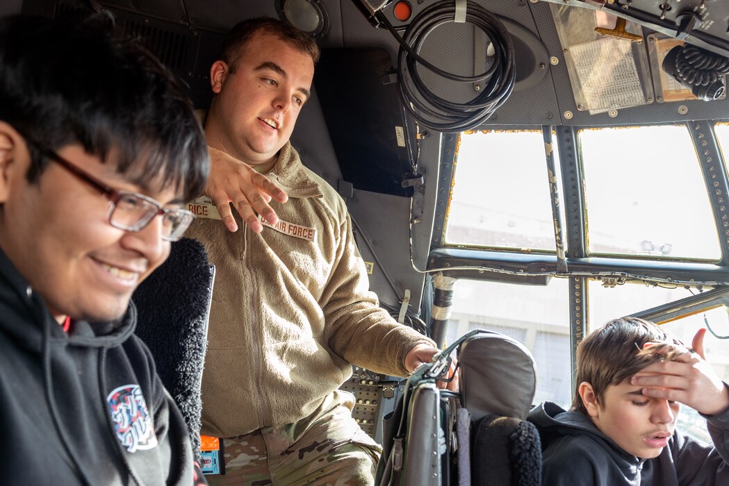 Airman explaining flight deck to students.