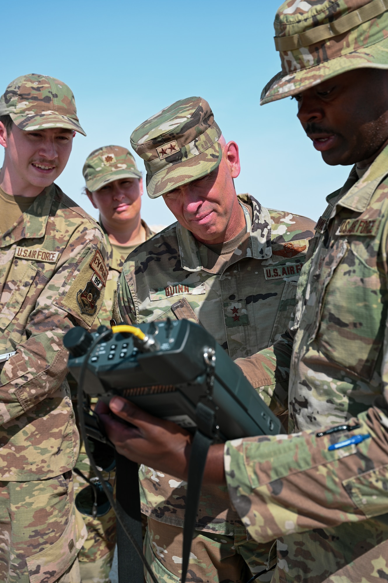 Members of Task Force 99 and Maj. Gen. Clark J. Quinn, Deputy Commander Ninth Air Force (Air Forces Central), observe a spectrum analyzer during new technology demonstration at Al Udeid Air Base, Qatar, November 18, 2022. TF99 was created to find innovative ways disrupt, degrade, and frustrate adversary systems and processes.(U.S. Air Force photo by Senior Airman Micah Coate)