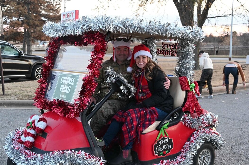 two people pose in decorated golf cart
