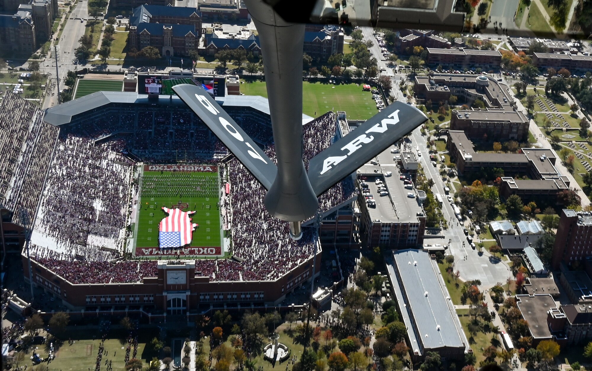 a tanker boom over a stadium and american flag shaped like the united states