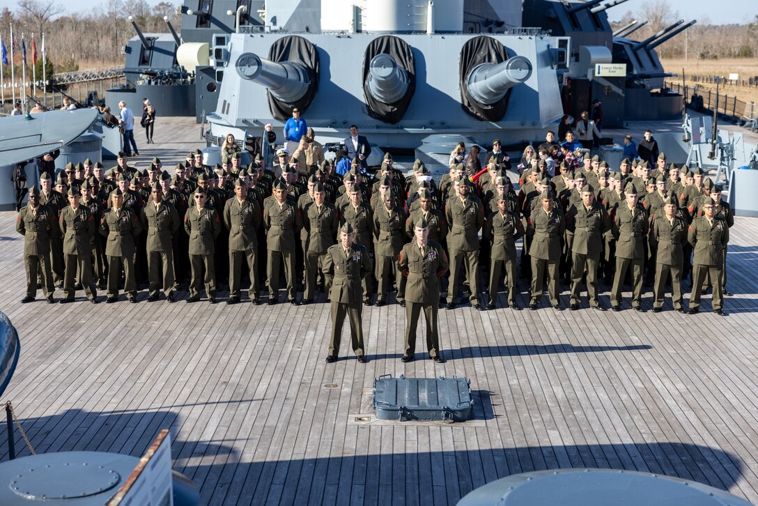 U.S. Marines from 1st Battalion, 8th Marine Regiment, stand in formation after a naturalization ceremony aboard the Battleship USS North Carolina, Dec. 2, 2022. 18 Marines from 15 countries and five continents swore the Oath of Allegiance and received their citizenship. Naturalization is the process by which U.S. citizenship is granted to a foreign citizen after he or she fulfills the requirements to become a citizen established by Congress in the Immigration and Nationality Act of 1965. (U.S. Marine Corps photo by Cpl. Timothy Fowler)