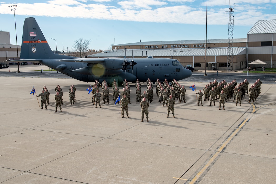 Airmen posing in front of aircraft for unit photo.