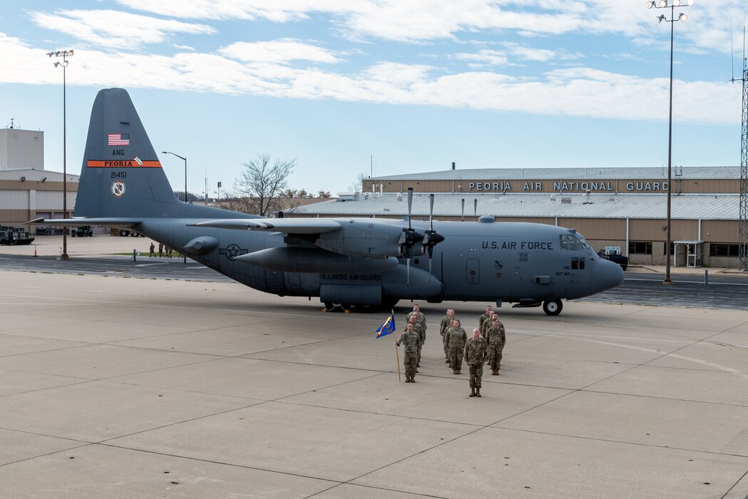 Airmen posing in front of aircraft for unit photo.
